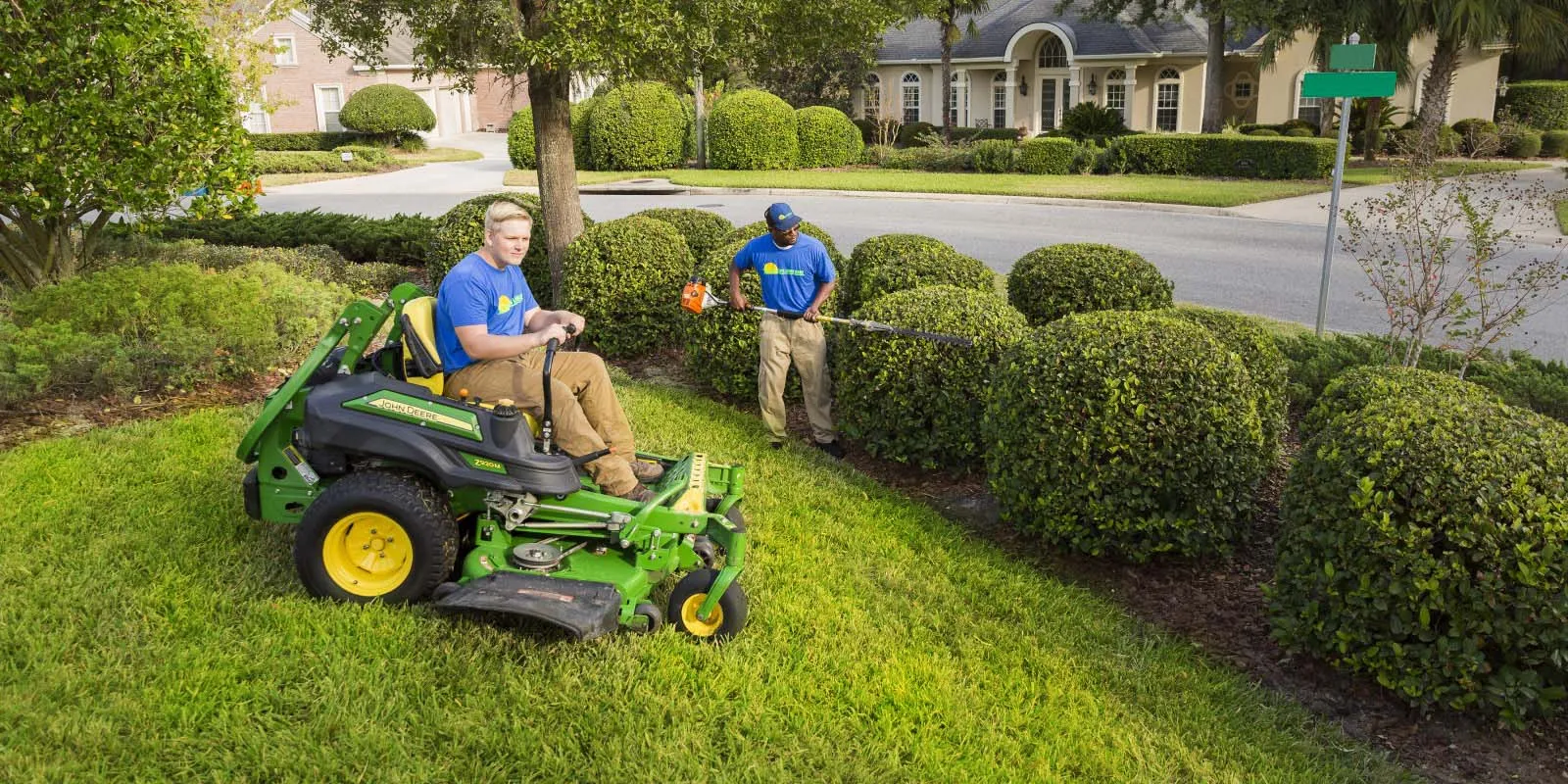 lawn maintenance technicians mowing and trimming landscape