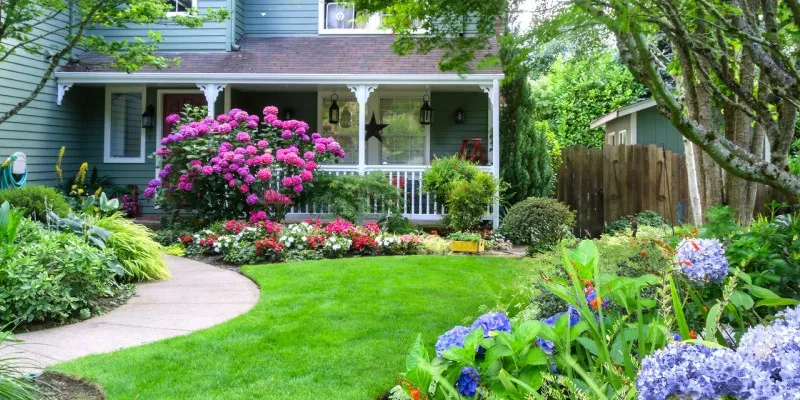beautiful front yard landscape with green grass and flowers